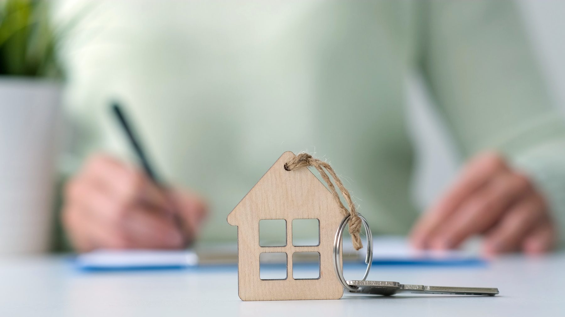 Schlüsselanhänger in Hausform auf Vertragsunterlagen